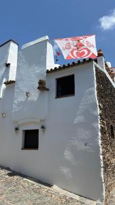 a white building with a flag on top of it at Casa Dom Dinis in Monsaraz