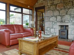 a living room with a couch and a fireplace at Sauchenshaw Cottage in Maryculter