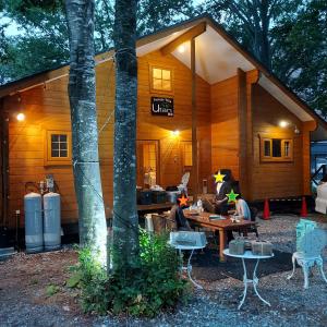 a group of people sitting at a table outside of a cabin at Private Villa Utan in Iiyama