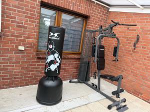 a gym with a black object next to a brick wall at WG-Zimmer-Monteurzimmer-Ferienwohnung bis 10 Personen in Aldenhoven