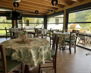 a dining room with tables and chairs and windows at Zvjezdana dolina Garni hotel in Andrijevica