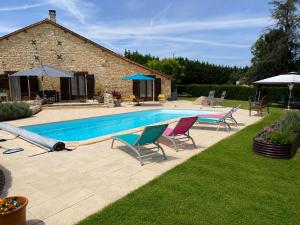 a swimming pool in a yard with chairs and umbrellas at Maison M in Surin +40 photos