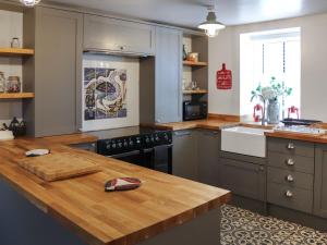 a kitchen with a wooden counter top and a stove at The White Anchor in Newborough