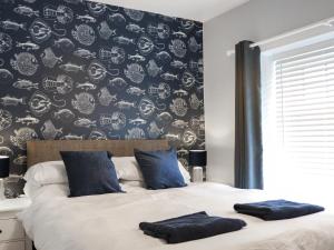a bedroom with a bed with blue pillows on it at The White Anchor in Newborough +12 photos