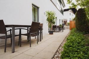 a patio with chairs and a table and a table and chairs at Apartments Obernosterer in Kaprun