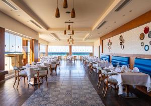 a dining room with white tables and chairs at Tropitel Sahl Hasheesh in Hurghada