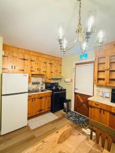 a kitchen with a white refrigerator and wooden cabinets at Private Guest Suit-Self Checkin-Near Downtown in Charlottetown