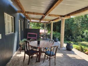 a patio with a table and chairs under a pergola at ROCKABILLY RANCH Self-Catering Guest Units in Pietermaritzburg