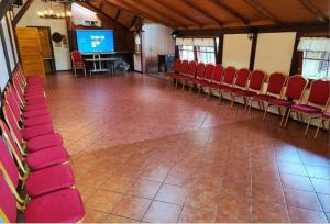 a large room with red chairs and a screen at Zajazd PTTK Pod Roztoką in Rytro