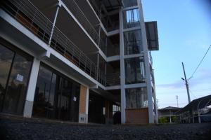 a tall building with windows and a windmill at Palmeras 2 in Manizales