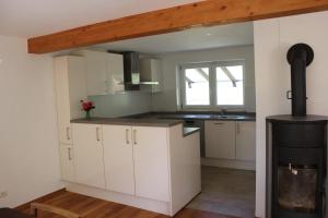 a kitchen with white cabinets and a stove at Erholung im Grünen in Weissach +7 photos