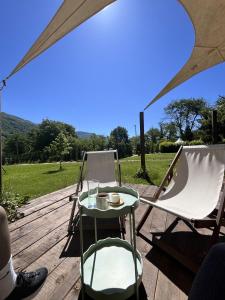 a table and chairs on a wooden deck with an umbrella at Zvjezdana dolina Garni hotel in Andrijevica