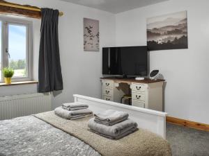 a bedroom with a bed and a tv and towels at New House Farm - Ukc6912 in Leck