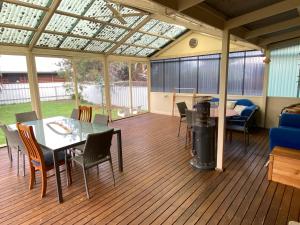 a screened in porch with a table and chairs at Goolwa Retreat in Goolwa North