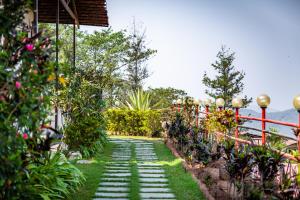 a garden path with plants and a red fence at Cloud 9 Hills Resort in Lonavala