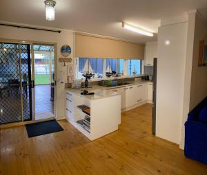 a kitchen with white cabinets and a counter top at Goolwa Retreat in Goolwa North +25 photos
