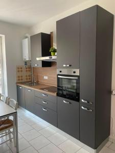 a kitchen with gray cabinets and a stove at Como Lake Grigna in Bellagio