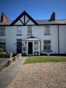 a white house with a porch and a driveway at The Hideaway in Llandudno