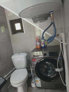 a small bathroom with a toilet and a washing machine at Tsiskari in Tsaldashi