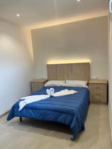 a bedroom with a blue bed with two white towels on it at Albergue Hostel Barosa in Barro