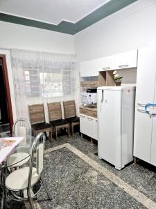 a kitchen with a refrigerator and a table and chairs at Casa Verde in Limeira