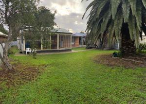 a house with a palm tree in the yard at Goolwa Retreat in Goolwa North