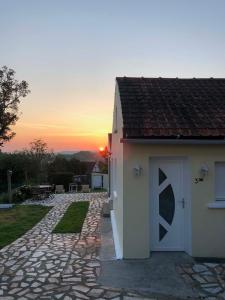 a small white building with a sunset in the background at Sable d or wissant in Wissant