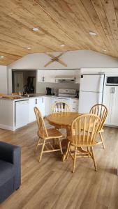 a kitchen with a wooden table and two chairs and a table at Chalet Ohana in Adstock +27 photos