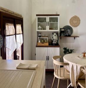 a kitchen with white cabinets and a table with chairs at Sale34 in Marsala