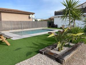 a backyard with a swimming pool and green grass at Casa Rural MESTRE in Deltebre
