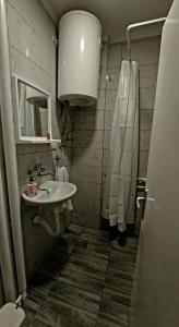 a white bathroom with a sink and a mirror at City Nest in Vršac