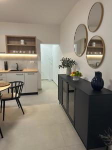 a kitchen with a black counter and a table and mirror at Apartments Seafront in Pupnat +16 photos