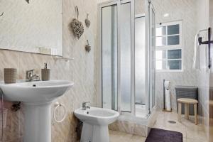 a white bathroom with a sink and a toilet at Casa MiRaMar in Mosteiros +25 photos