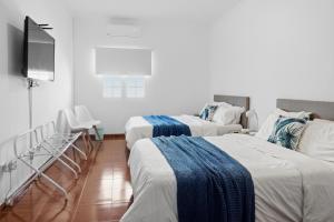 a room with two beds and a flat screen tv at Casa MiRaMar in Mosteiros