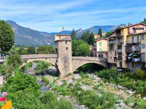 a stone bridge over a river in a town at studio stella in Sospel