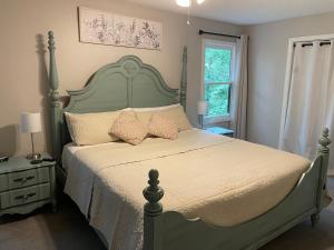 a bedroom with a large bed with a green headboard at Golf, Hot tub, Arcade, Poker Table, Wildlife, Internet, Pet Friendly, Name-May the Course Be With You in Ellijay +27 photos