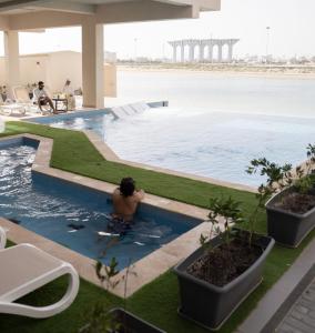 a man in a swimming pool in a building at Faris Villas للعائلات فقط-الصفحة الرسمية لمنتجع فلل فارس in Al Khīrān