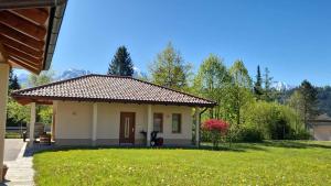a small house in a yard with a green lawn at Haus Leblhuber in Windischgarsten