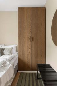 a bedroom with a wooden cabinet next to a bed at 5BR 2Bath Frogner - Parking - Vigelandsparken in Oslo
