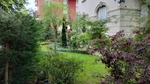 a garden with trees and bushes in front of a house at NOBILI LIBARDI - VILLA BASEVI in Verona