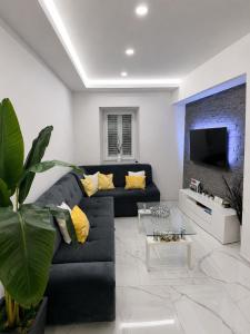 a living room with a black couch and a tv at Holiday house Marea in Bribir