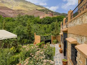 a house with a garden with flowers on a balcony at Tonaroz House in Imlil
