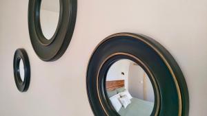a mirror hanging on a wall with a bed at Logement indépendant dans villa direct plage Lac Leman Evian in Publier