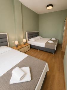 a room with two beds and two tables with lamps at Kobuleti Garden Inn in Kobuleti +57 photos