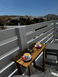 a wooden table with two cups of coffee on a balcony at Naousa Nest in Naousa