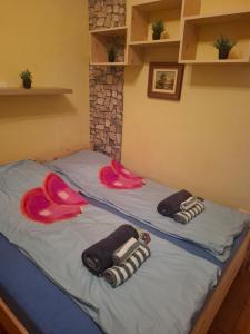 two beds in a room with towels on them at Juci Home Apartman in Vonyarcvashegy +2 photos