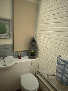 a white bathroom with a toilet and a sink at The Hideaway in Llandudno +44 photos