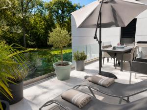 a patio with two chairs and an umbrella at Contemporary villa between Paris and Disneyland in Champs-sur-Marne