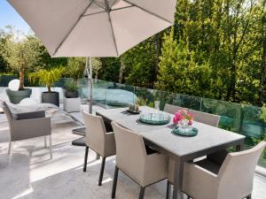 a table with chairs and an umbrella on a patio at Contemporary villa between Paris and Disneyland in Champs-sur-Marne