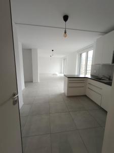 an empty kitchen with white cabinets and a tile floor at Paradise 31 in Paradiso